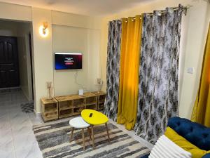 尼耶利Ruby Modern Homes-1br-Nyeri, King'ong'o-Marriott的客厅配有黄色窗帘和黄色桌子