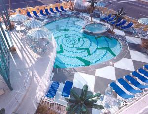 怀尔德伍德斯达鲁斯酒店的享有带椅子和遮阳伞的游泳池的上方景色