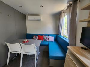 CieuxLe clos de lignac的小房间设有蓝色的沙发、桌子和椅子