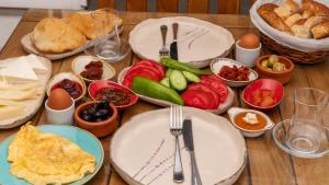 阿拉恰特Avlu Alaçatı Boutique Hotel的木桌,上面放有盘子和碗的食物