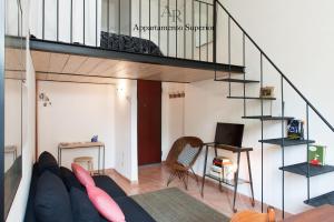 恩波利Appartamenti Ridolfi的带沙发和螺旋楼梯的客厅