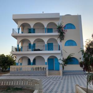 杰尔吉斯Dar El Ferdaous的一栋带蓝色门和阳台的建筑