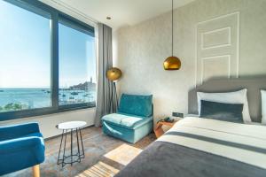 罗维尼德尔芬酒店的卧室配有床、椅子和窗户。