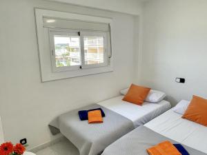 拉皮内达APARTBEACH BELL RACO ESQUINERO y FRENTE PLAYA的带窗户的客房内的两张床