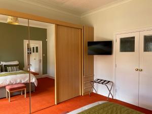 艾尔布莱克别墅住宿加早餐旅馆的一间卧室配有一张床,墙上配有电视