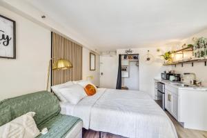 檀香山Bright & Cozy Condo Unit with Balcony!的一间带床的小卧室和一间厨房