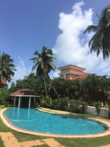 莫尔穆冈1BHK Luxury Homestay In Betalbatim, South Goa的一个带凉亭和棕榈树的游泳池
