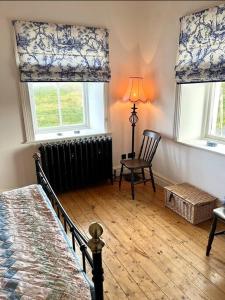 BurtonportTraditional Donegal house on the Wild Atlantic Way的一间卧室配有床、暖气和2个窗户。