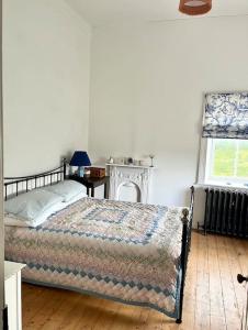 BurtonportTraditional Donegal house on the Wild Atlantic Way的一间卧室设有一张床和一个窗口