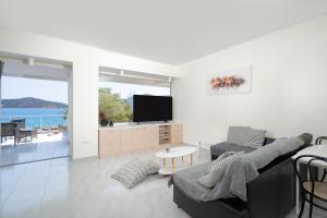 拉夫蒂港Phos Apartment by A&D Properties的客厅配有电视、沙发和桌子