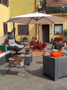 卡西诺Le Camerette di Edda的庭院设有桌子和遮阳伞,鲜花盛开