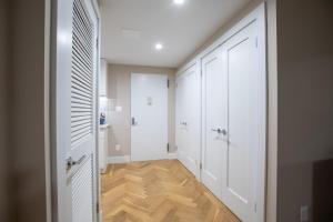 纽约Cozy Apartment in Upper East Side的走廊设有白色门和木地板