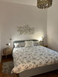 法纳诺Casa Blanche的一间卧室配有一张床、两盏灯和吊灯。