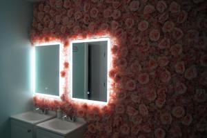 迈阿密Art Gardens Wynwood concept的浴室设有两个盥洗盆和一面红灯镜子