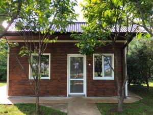 古达乌塔Vse Dlya Vas Guest House的一间小房子,拥有白色的窗户和树木