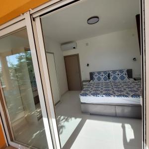 巴尔巴特纳拉布5 rooms apartman的一间卧室设有一张床和一个滑动玻璃门