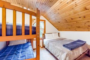 Mount HollyParadise in Mount Holly的小型客房设有两张双层床和木制天花板。