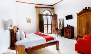 格拉纳达雷亚尔梅赛德酒店的一间卧室配有一张床和一张红色椅子