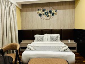 帕罗Silver Cloud Hotel的一间卧室配有一张大床和一个吊灯。