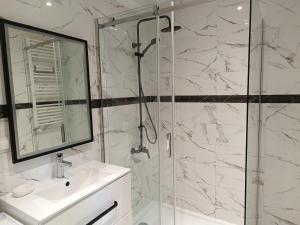 奥瓦瓦Apartament Rodzinny的带淋浴、盥洗盆和镜子的浴室
