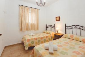 科尼尔-德拉弗龙特拉Villa la Dehesa的一间卧室设有两张床和窗户。