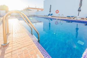 科尼尔-德拉弗龙特拉Villa la Dehesa的一个带蓝色水和金属栏杆的游泳池