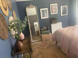 瑞米耶日la planque d'hugo的卧室配有镜子和一张桌子及一张床