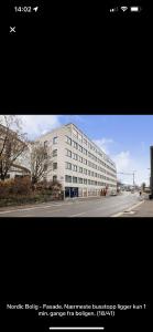 卑尔根MK8 Apartment的街道上一所白色大建筑的两张照片