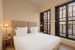 马拉喀什达尔卡玛摩洛哥传统庭院（住宅）的卧室设有一张带窗户的白色大床