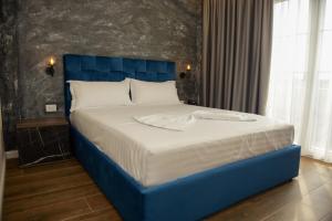 斯库台Hotel Royal的卧室内的一张带蓝色床头板的大床