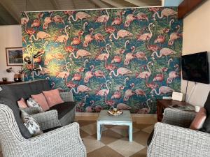 Dorp Sint MichielTip! Blue Bay Beachvilla 12 - Blue Bay Resort的客厅配有粉红色火烈鸟的大壁画
