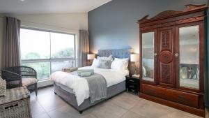 开普敦Noordhoek Bliss Beach House的一间卧室设有一张大床和一个大窗户
