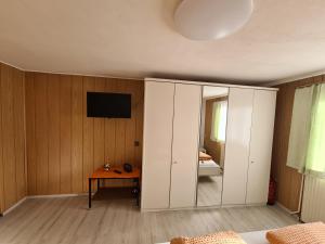 上陶恩Ferienwohnung Jürgen horn的卧室配有白色橱柜和墙上的电视。