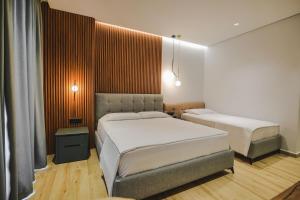 卡萨米尔Ori Mare Hotel的一间卧室,配有两张床