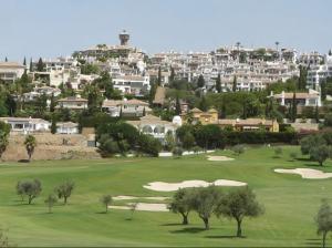 福恩吉罗拉Luxury Suites Fuengirola的一座有树木和建筑背景的高尔夫球场