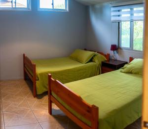 安加罗阿Cabañas Raupa的配有绿床单的客房内的两张床