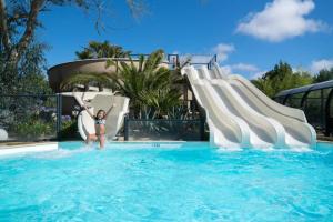 特雷甘克MH VAL&YVAN plage, piscine pointe de Trévignon et concarneau的站在游泳池水滑梯上的女孩