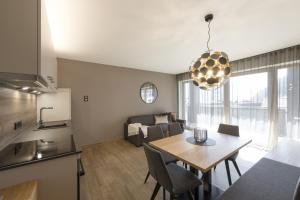 拉布拉Residence Sonja - Apartment Fagus的厨房以及带桌子和沙发的客厅。