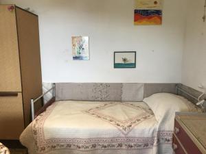 维拉皮亚纳Casa Patrizia的卧室内的一张床铺,墙上有两张照片