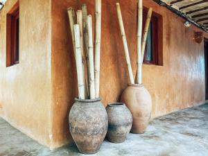 普拉纳维瑙El Sitio de Playa Venao的三个花瓶坐在墙上,有竹杆