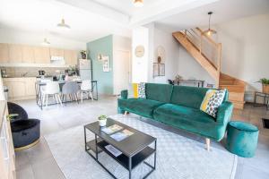 La Ville-aux-DamesLe Gîte des Dames - 6 personnes PISCINE chauffée的客厅配有绿色沙发和桌子