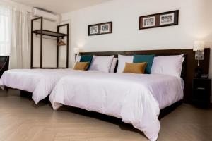 苏瓦Capricorn Hotel Suva的一间卧室配有两张带白色床单的床