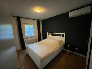 奥斯特豪特Nature & golf Villa的卧室配有白色的床和窗户。