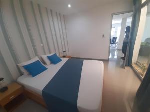 普拉亚Apto T1 Comfort的一间卧室配有一张带蓝色枕头的大床