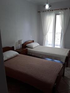 SpartokhórionTheros Apartment的一间卧室设有两张床和窗户。