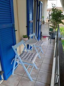 SpartokhórionTheros Apartment的天井配有两把椅子和一张桌子,并拥有一扇蓝色的门