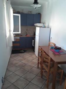 SpartokhórionTheros Apartment的厨房配有桌子和白色冰箱。