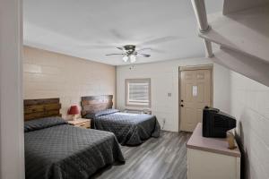 EmoryAxtons Bass City Resort的一间卧室配有两张床和吊扇