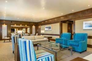 亚松森亚松森喜来登酒店的客厅配有蓝色椅子和沙发