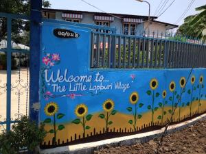 华富里华富里府小村庄民宿的一座带向日葵的栅栏壁画